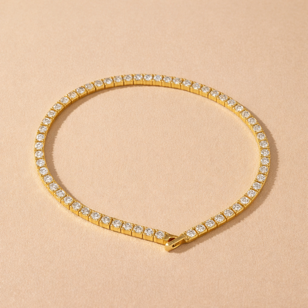 A gold-plated adjustable tennis bracelet for women on a cream background