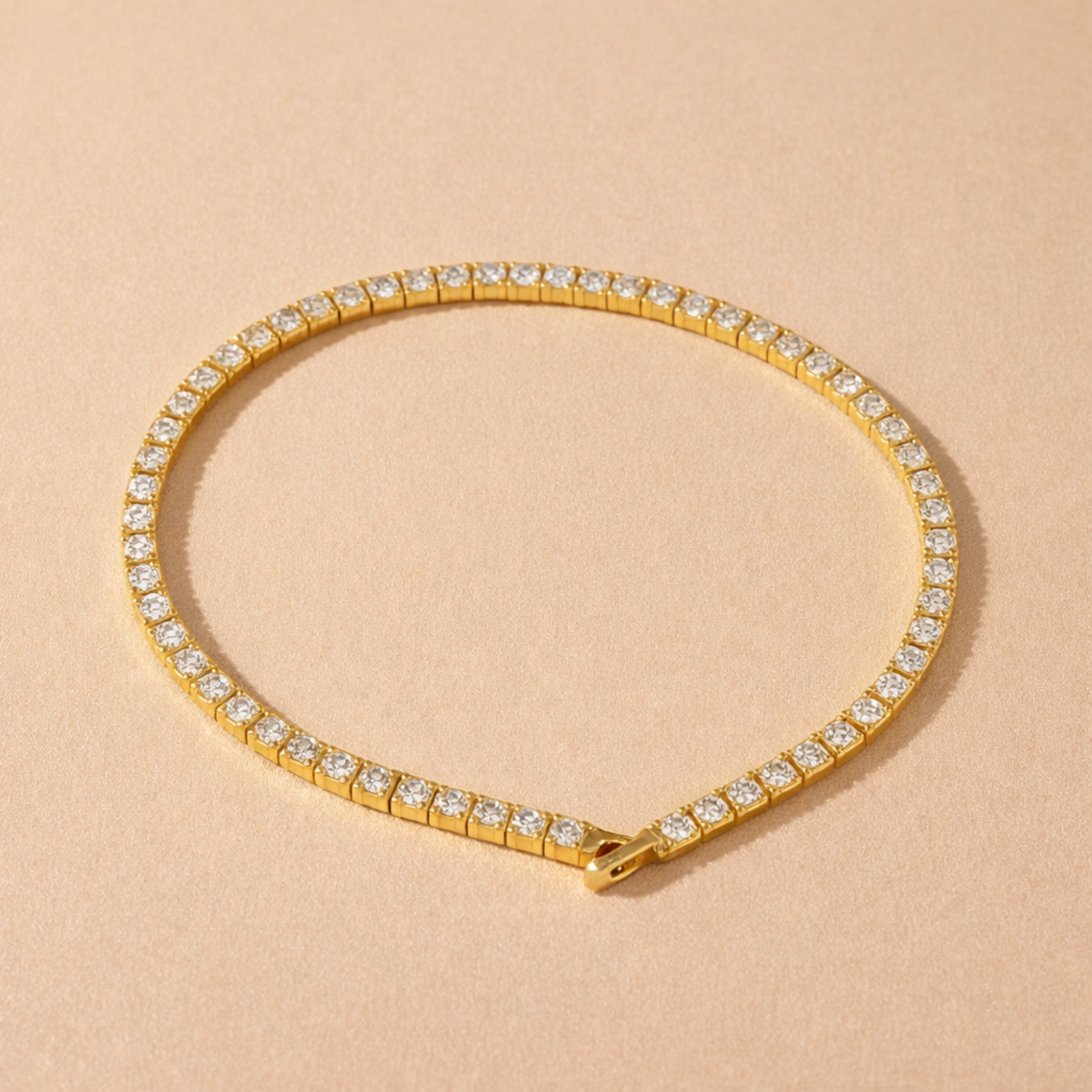 A gold-plated adjustable tennis bracelet for women on a cream background