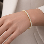 A gold-plated adjustable tennis bracelet for women on a model hand