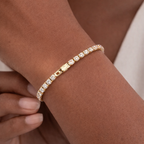 A gold-plated adjustable tennis bracelet for women on a model hand