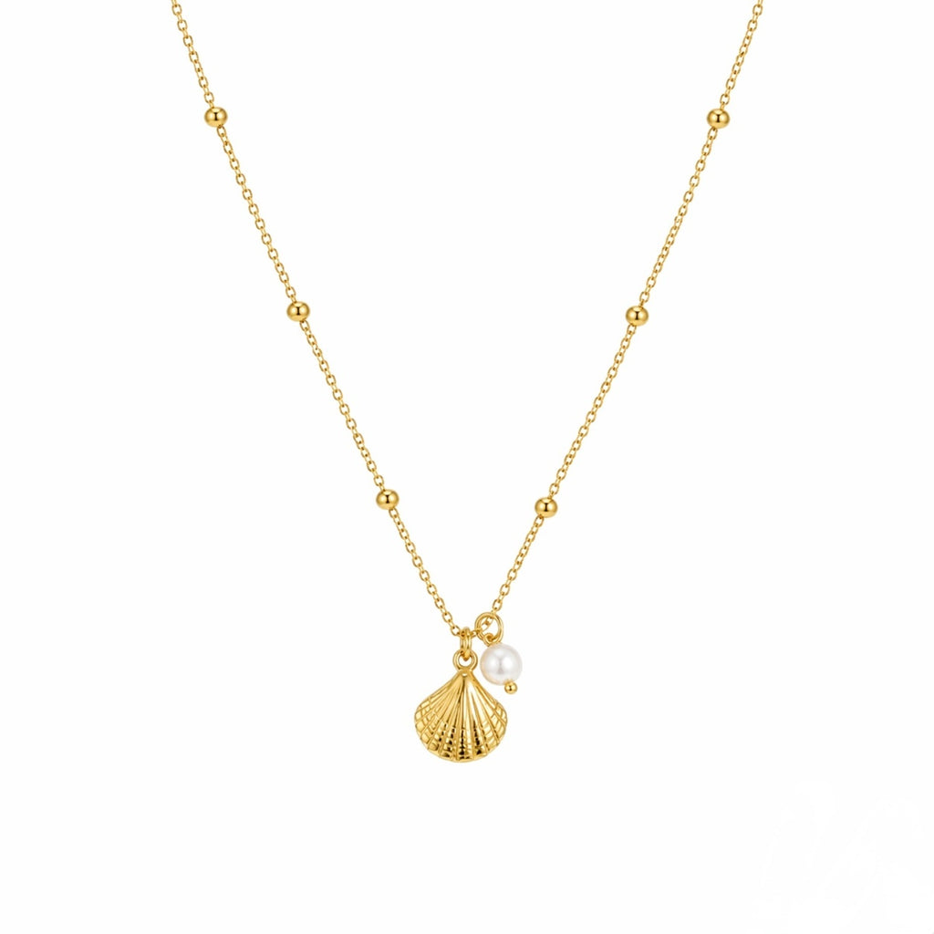 Gold necklace with a shell and pearl pendant on a white background