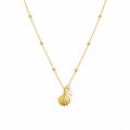 Gold necklace with a shell and pearl pendant on a white background