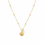 Gold necklace with a shell and pearl pendant on a white background
