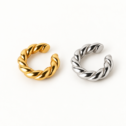 Two twisted open ear cuff, one in gold and one in silver, displayed on a clean white background.