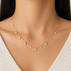 A gold-plated stainless steel chain for women featuring dangling crystal blossoms and round bezel-set crystal charms, shown on a model