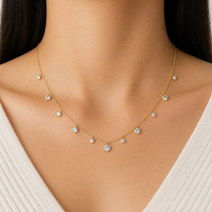 A gold-plated stainless steel chain for women featuring dangling crystal blossoms and round bezel-set crystal charms, shown on a model