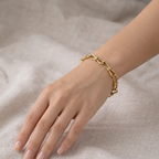 A gold-plated link chain bracelet for women featuring delicate knot details on a model hand