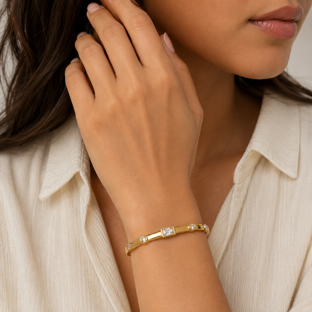 A gold-plated bracelet for women featuring crystal inlays, organic textures, and modern geometric designs, shown on a model