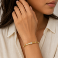 A gold-plated bracelet for women featuring crystal inlays, organic textures, and modern geometric designs, shown on a model