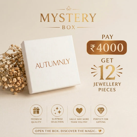 Autumnly Mystery Box promotional graphic showing a white gift box with the brand name 'AUTUMNLY' on the lid, and text offering a ₹4000 payment to get 12 jewellery pieces. Additional icons highlight premium quality, surprise selection, value, and gift suitability.
