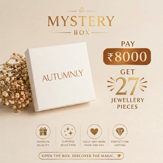 Autumnly Mystery Box promotional graphic showing a white gift box with the brand name 'AUTUMNLY', and text offering a ₹8000 payment to receive 27 jewellery pieces. Icons at the bottom highlight premium quality, surprise selection, value, and gift suitability.