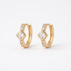 A pair of gold-plated huggie hoop earrings for women featuring a central kite-set princess-cut clear crystal, shown on a clean white background.