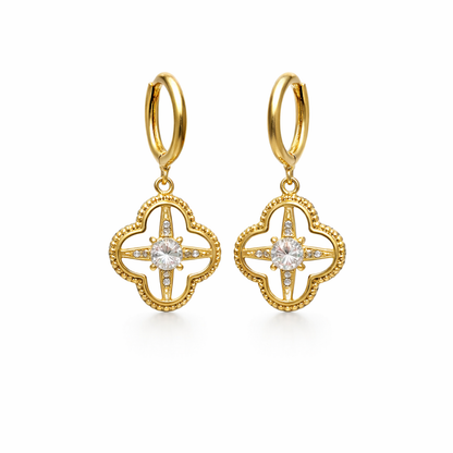 A pair of gold-plated hoop earrings for women featuring a dangling clover-shaped lattice charm with a central crystal stone, shown on a white background.