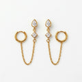 A pair of gold-plated ear chain earrings for women connecting a tiered crystal drop stud to a small gold hoop with a fine chain.