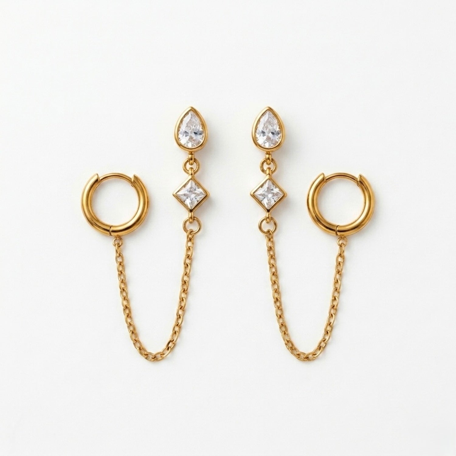 A pair of gold-plated ear chain earrings for women connecting a tiered crystal drop stud to a small gold hoop with a fine chain.