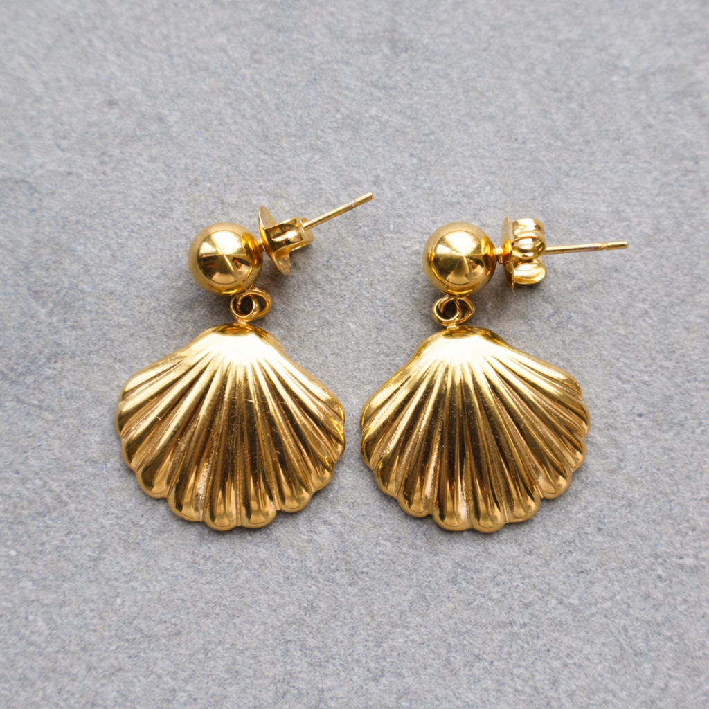 A pair of gold-plated shell drop earrings for women, featuring a smooth gold stud and a textured shell pendant, shown on a neutral textured background.