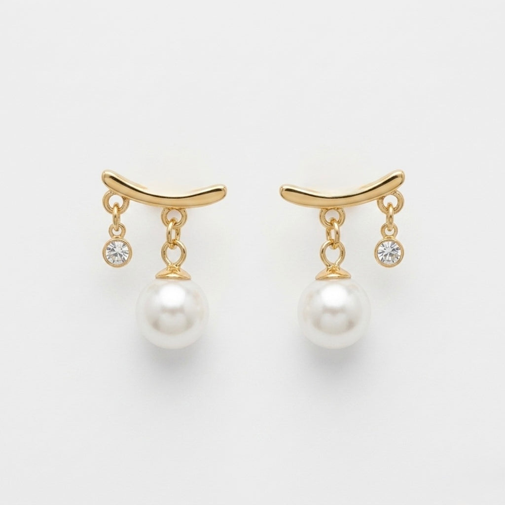A pair of gold-plated arc drop earrings for women featuring a central white pearl and a small clear crystal, shown on a white background.