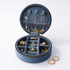 tealblue jewelry organizer with gold jewelry arranged across multiple compartments on a white background