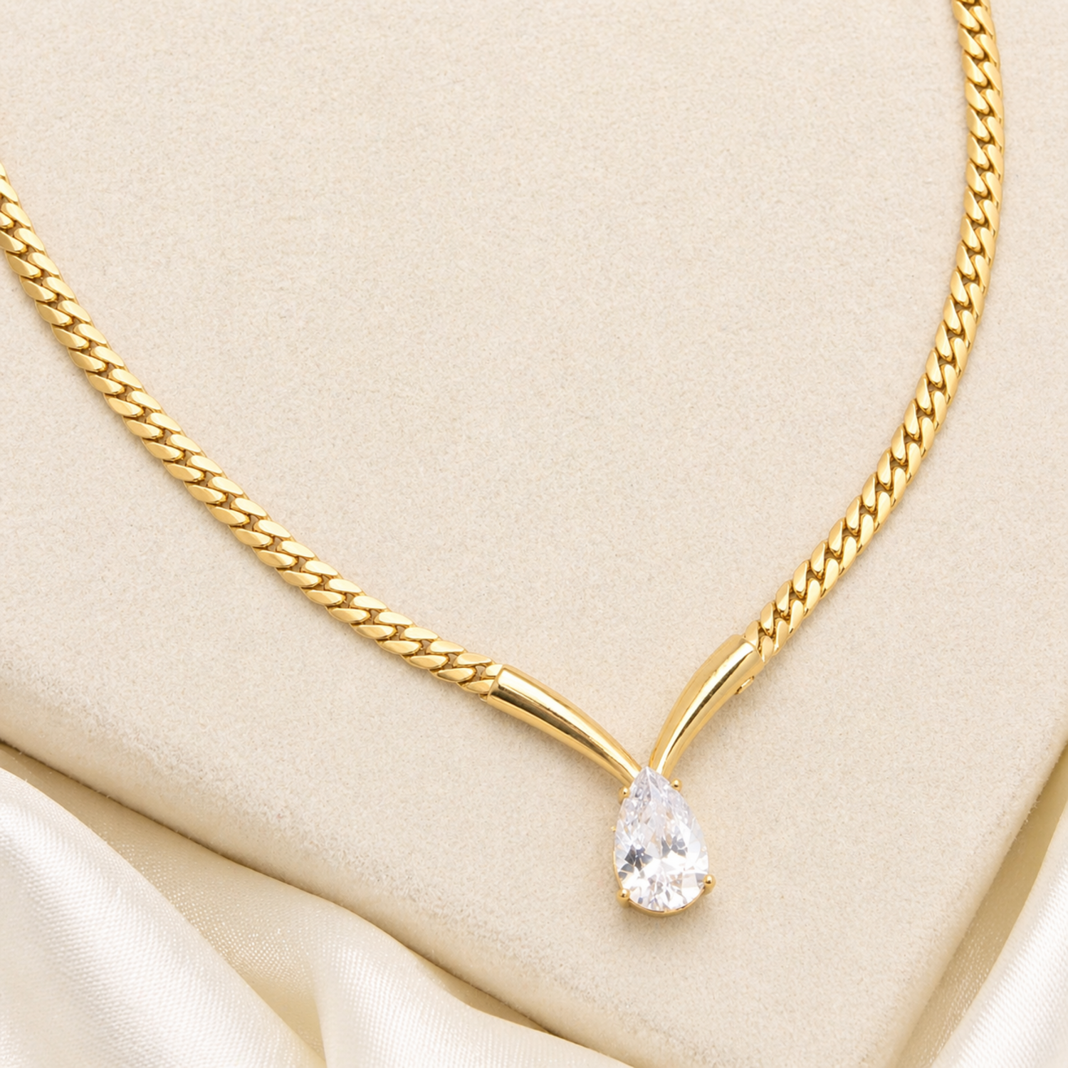 A gold-plated stainless steel chain for women featuring a V-shaped mounting and a large sparkling teardrop crystal pendant