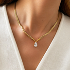 A gold-plated stainless steel chain for women featuring a V-shaped mounting and a large sparkling teardrop crystal pendant, shown on a model
