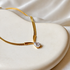 A gold-plated stainless steel chain for women featuring a V-shaped mounting and a large sparkling teardrop crystal pendant
