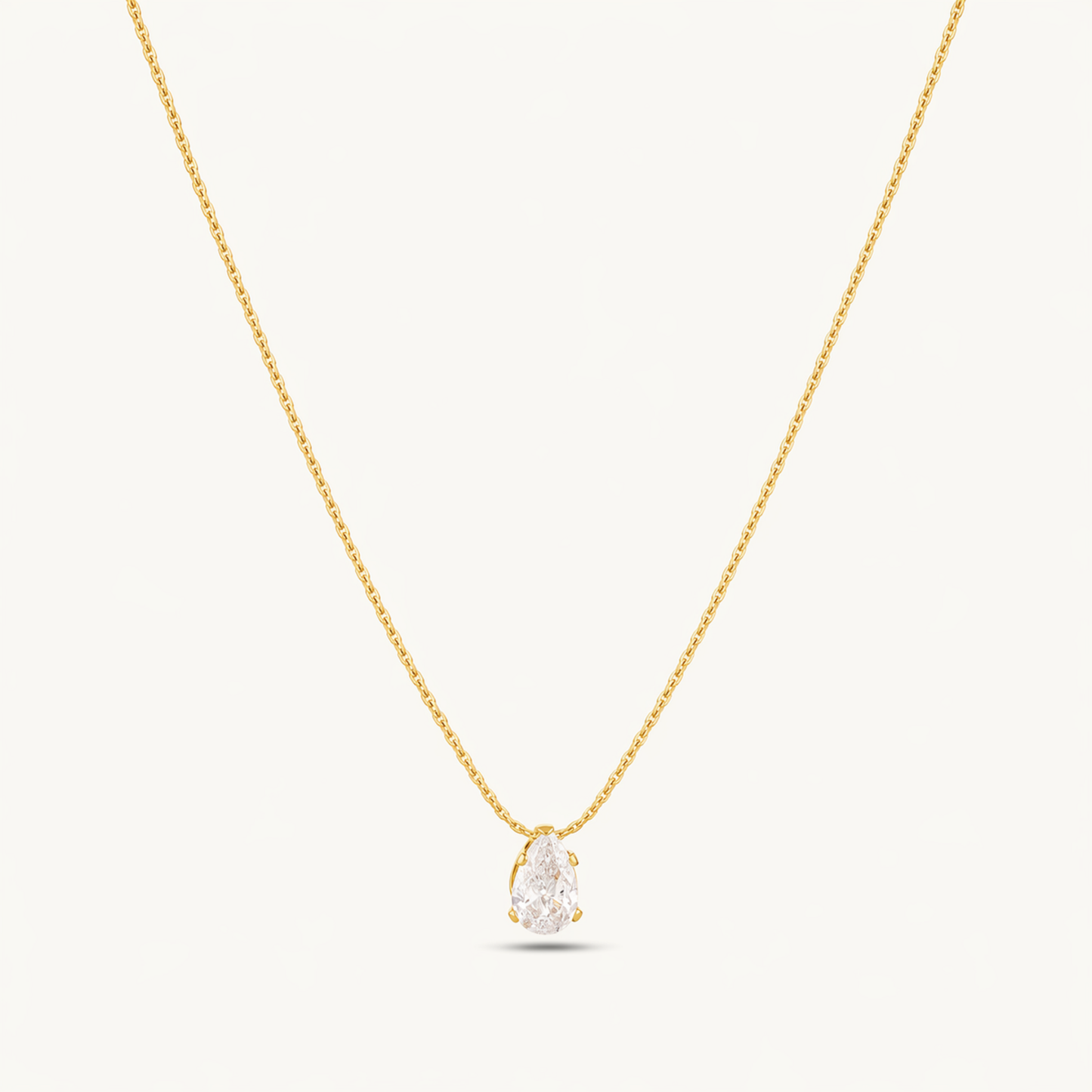 A gold-plated stainless steel chain for women featuring a single, brilliant pear-cut crystal pendant on a delicate link chain.