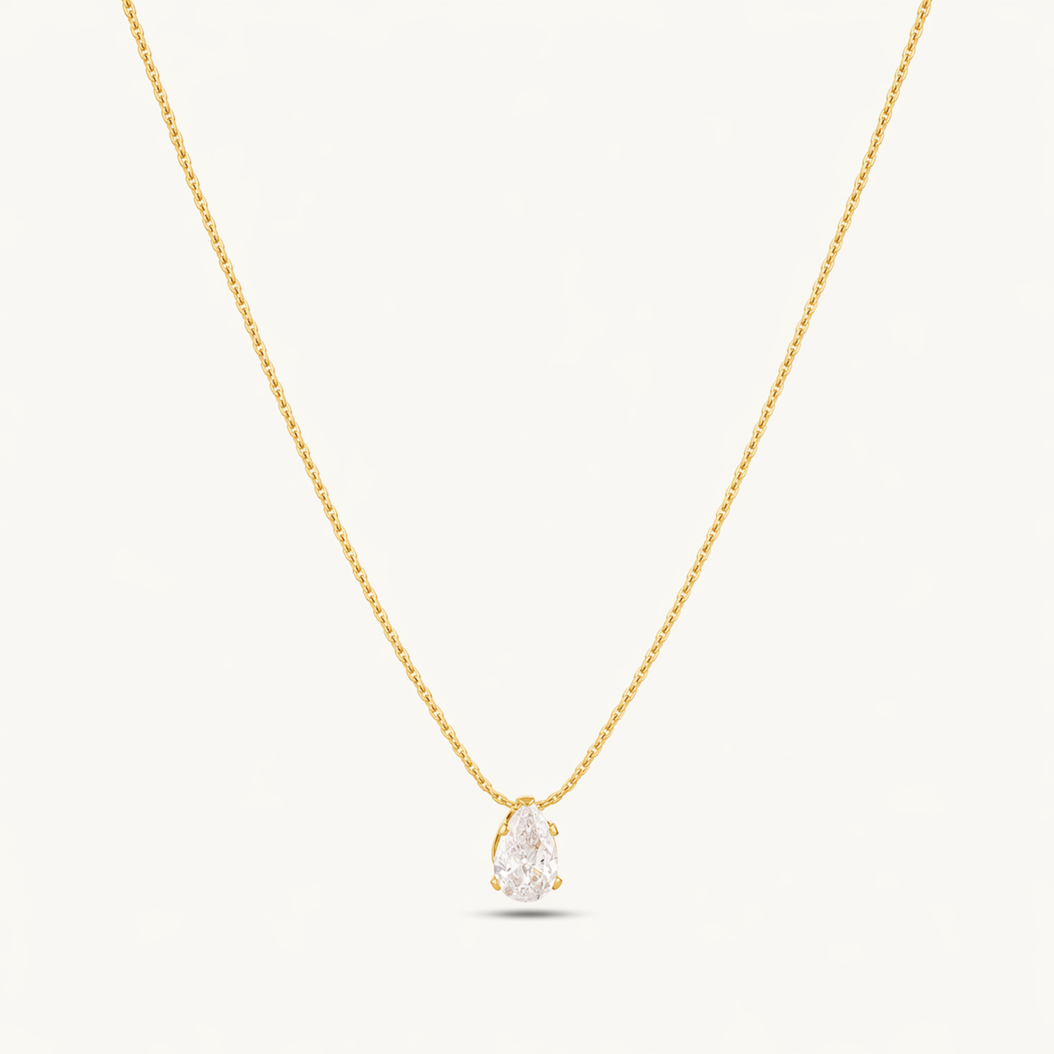 A gold-plated stainless steel chain for women featuring a single, brilliant pear-cut crystal pendant on a delicate link chain.