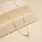 A close-view of a gold-plated stainless steel chain for women featuring a single, brilliant pear-cut crystal pendant on a delicate link chain.