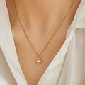 A gold-plated stainless steel chain for women featuring an organic, molten-gold pendant set with a single white pearl, shown on a model