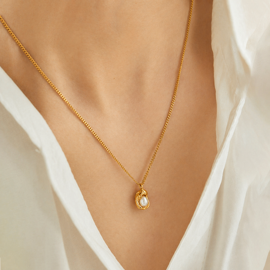 A gold-plated stainless steel chain for women featuring an organic, molten-gold pendant set with a single white pearl, on a model