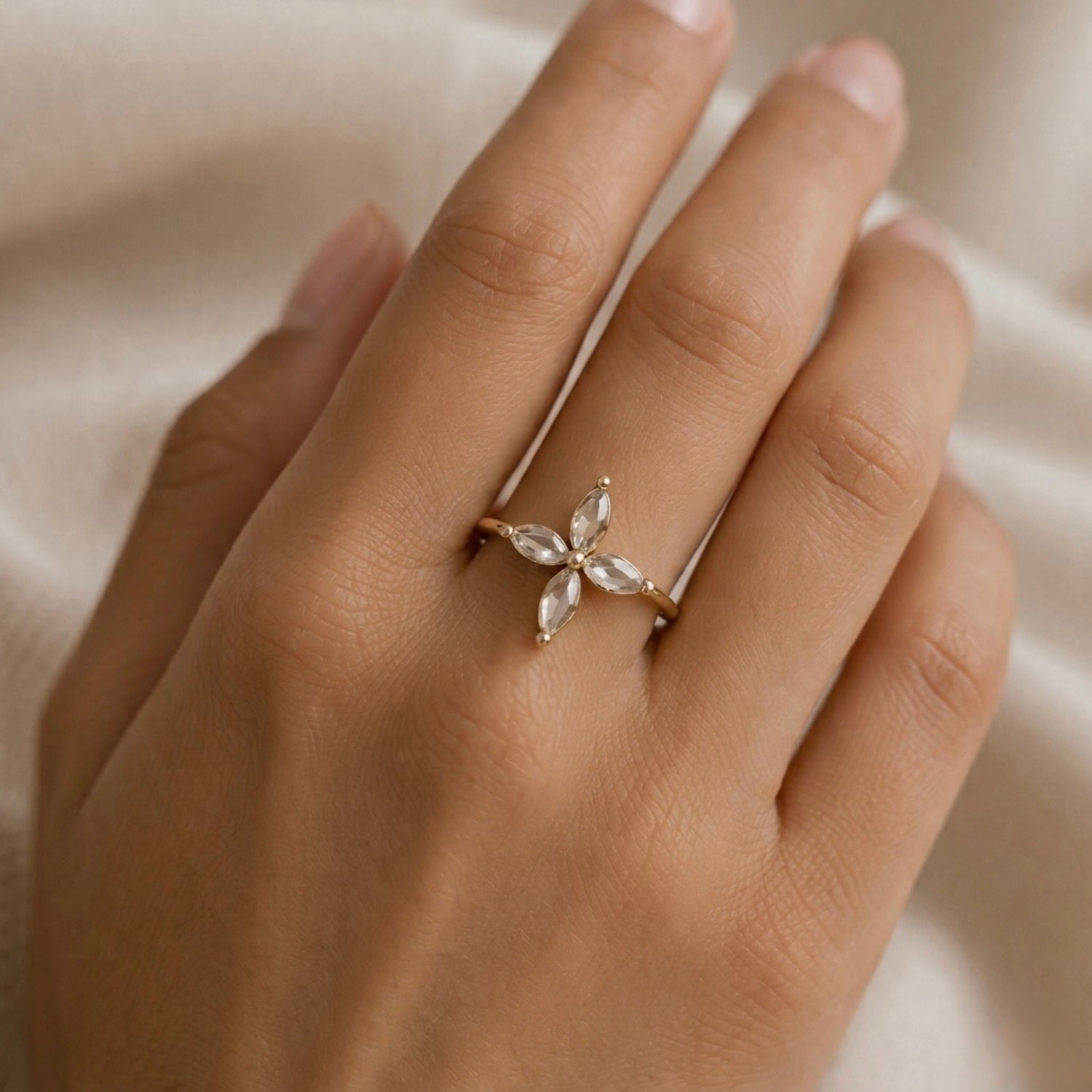 A close view of delicate gold plated adjustable ring for women featuring a four-petal flower design