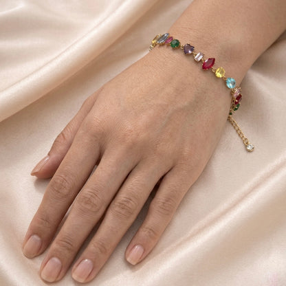 A gold-plated multi-color chain bracelet for women featuring various stone shapes on a model hand
