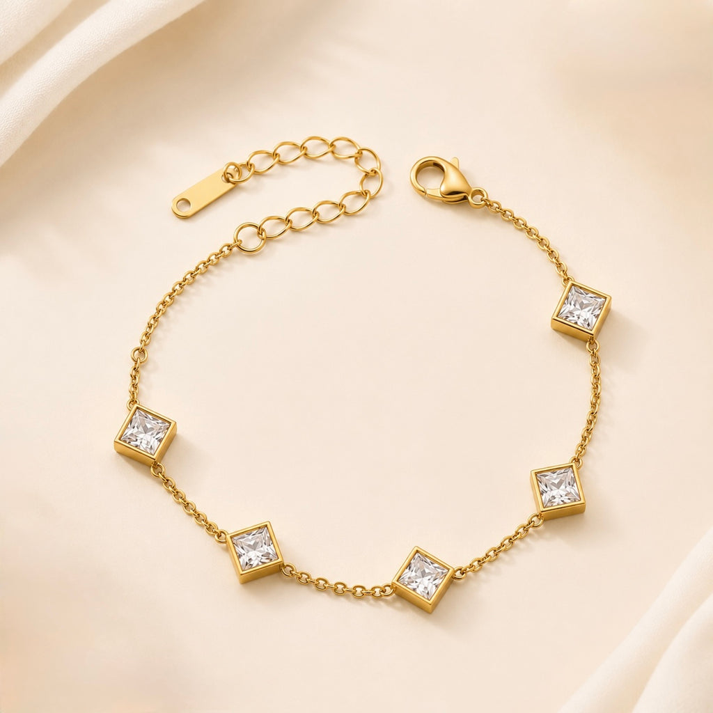 A close-view of a gold-plated ladies bracelet featuring a fine chain and five strategically spaced square-cut princess crystals in bezel settings.