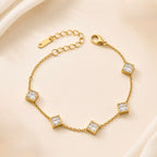 A close-view of a gold-plated ladies bracelet featuring a fine chain and five strategically spaced square-cut princess crystals in bezel settings.
