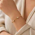 A gold-plated ladies bracelet featuring a fine chain and five strategically spaced square-cut princess crystals in bezel settings, shown on a model