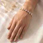 A gold-plated chain bracelet for women featuring a variety of stone cuts including round, marquise, and emerald shapes on a model hand