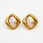 A pair of gold-plated abstract rhombus-shaped stud earrings for women featuring two floating crystals inside a molten gold frame, shown on a white background.