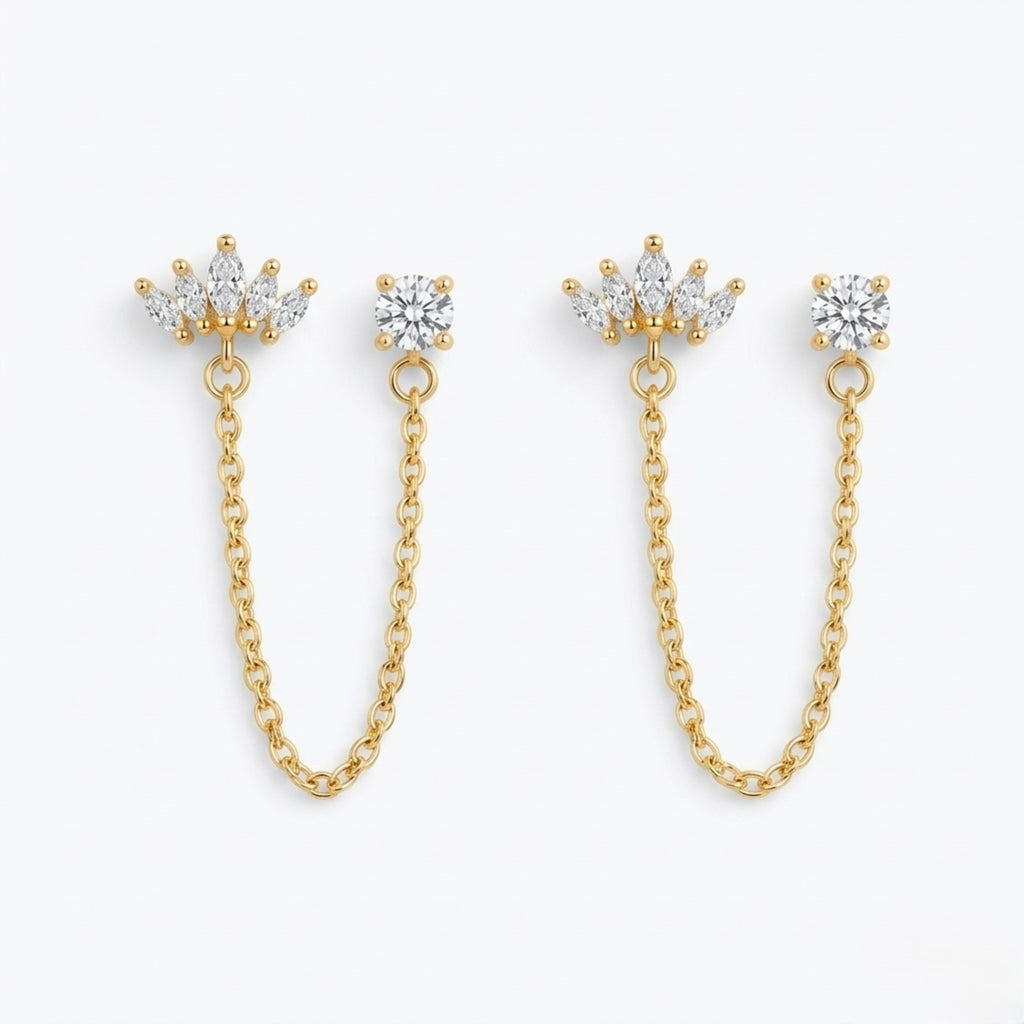 A pair of premium gold-plated ear chain earrings for women featuring a five-stone marquise crown stud and a round white stone stud connected by a delicate gold chain on a white background