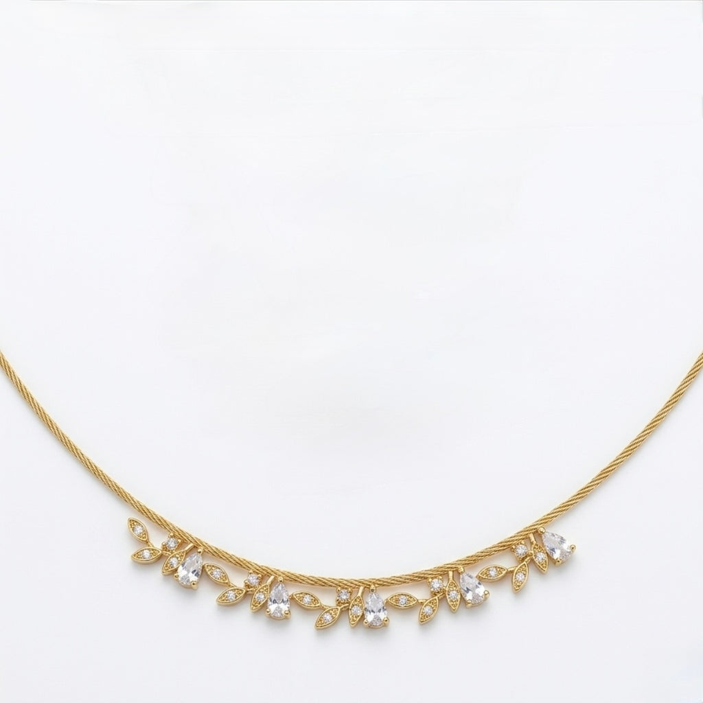 A close-view of a gold-plated stainless steel chain for women featuring a twisted cable design and a shimmering fringe of crystal leaf charms