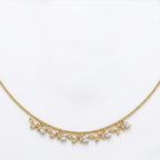 A close-view of a gold-plated stainless steel chain for women featuring a twisted cable design and a shimmering fringe of crystal leaf charms