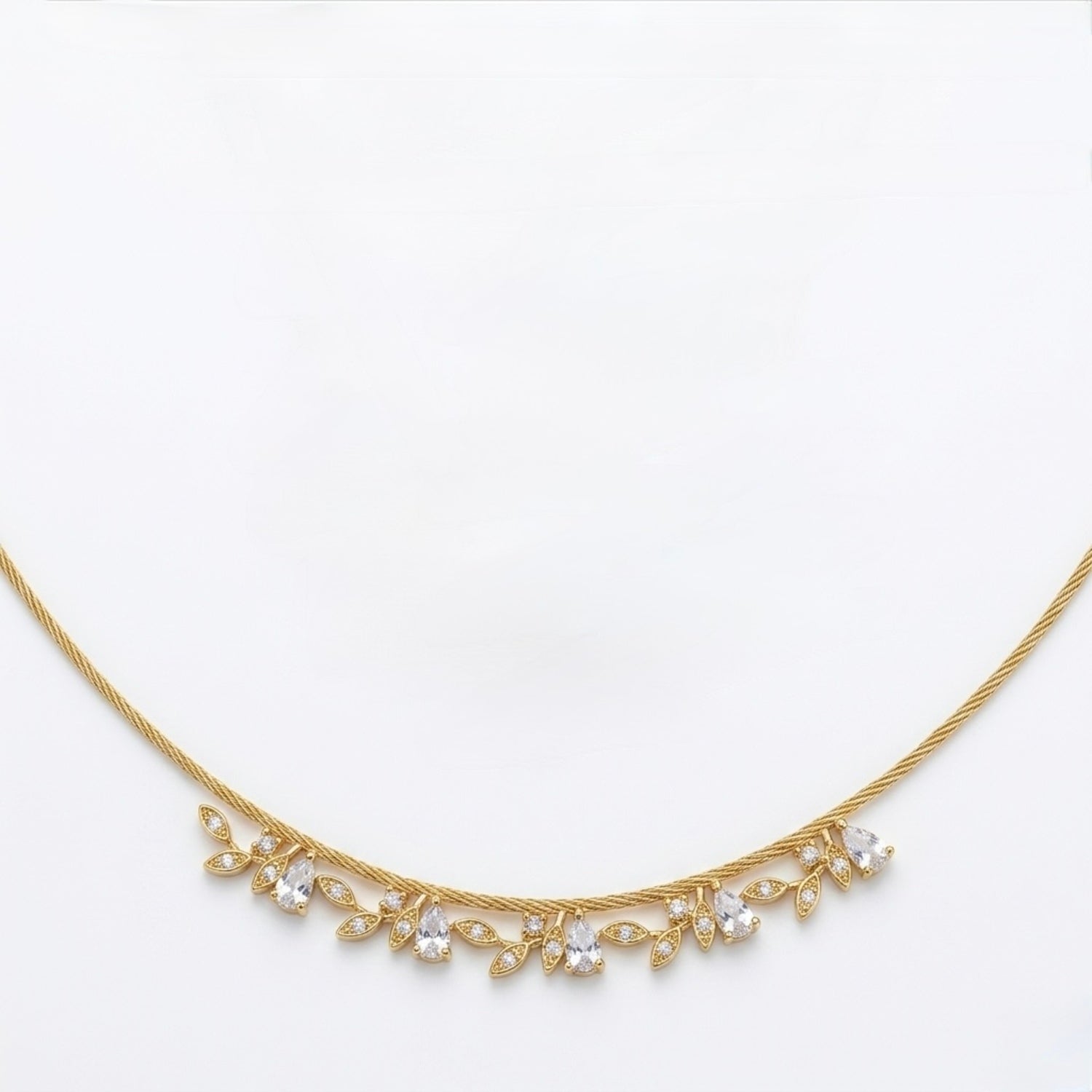 A close-view of a gold-plated stainless steel chain for women featuring a twisted cable design and a shimmering fringe of crystal leaf charms