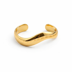 A bold and wide gold-plated organic wave cuff bracelet for women with a smooth, thick finish, displayed on a white background