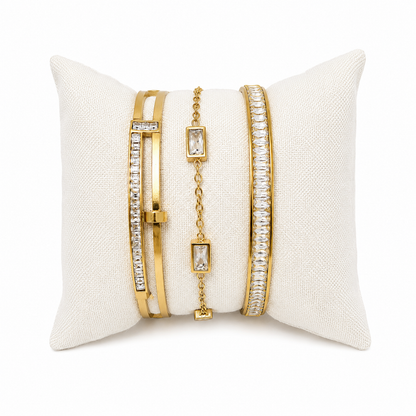 A premium three-piece gold-plated bracelet stack for women featuring two geometric crystal station bangles and a central multi-cut crystal statement chain bracelet.
