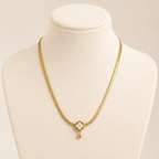 A gold-plated stainless steel chain for women featuring a flat high-shine texture and an open clover pendant with a small gold drop shown on display