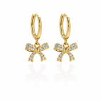 A pair of gold-plated hoop earrings for women featuring a sparkling crystal-encrusted bow drop, shown on a white background