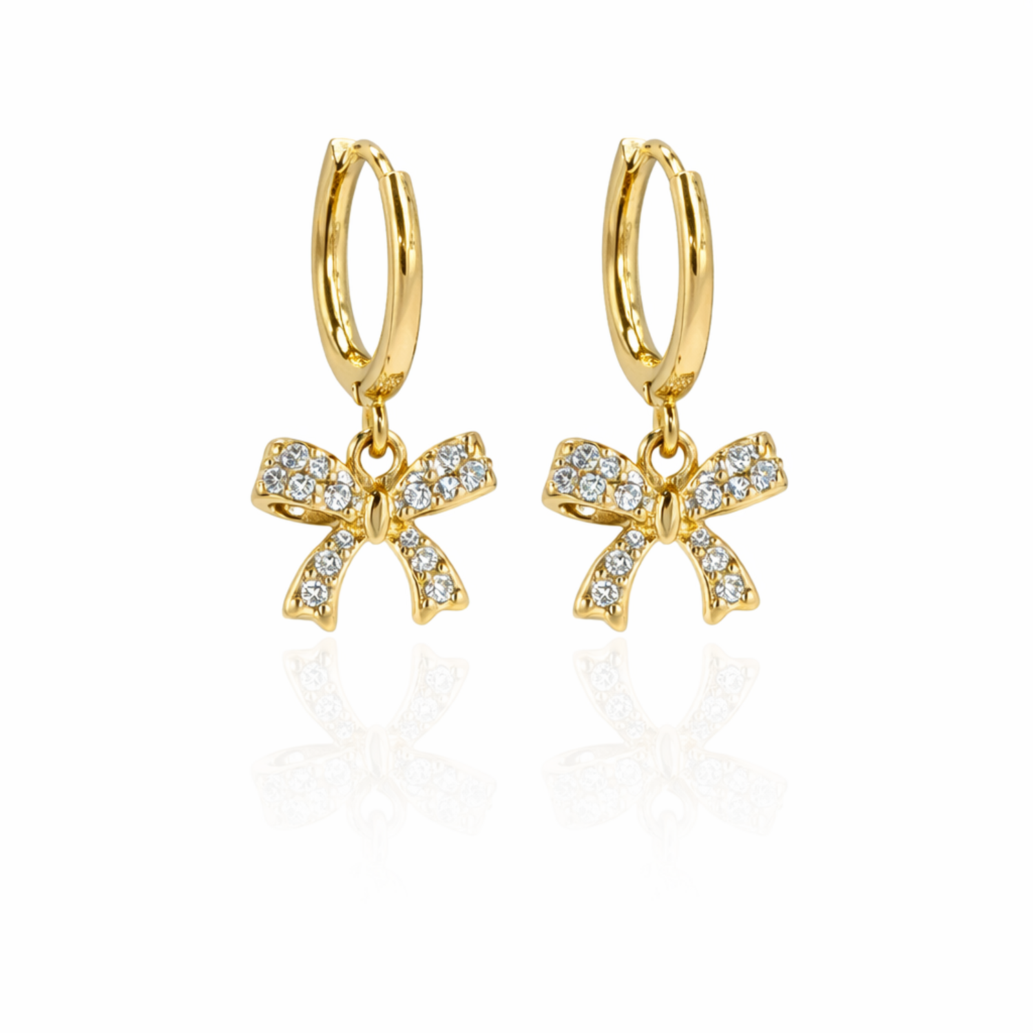 A pair of gold-plated hoop earrings for women featuring a sparkling crystal-encrusted bow drop, shown on a white background