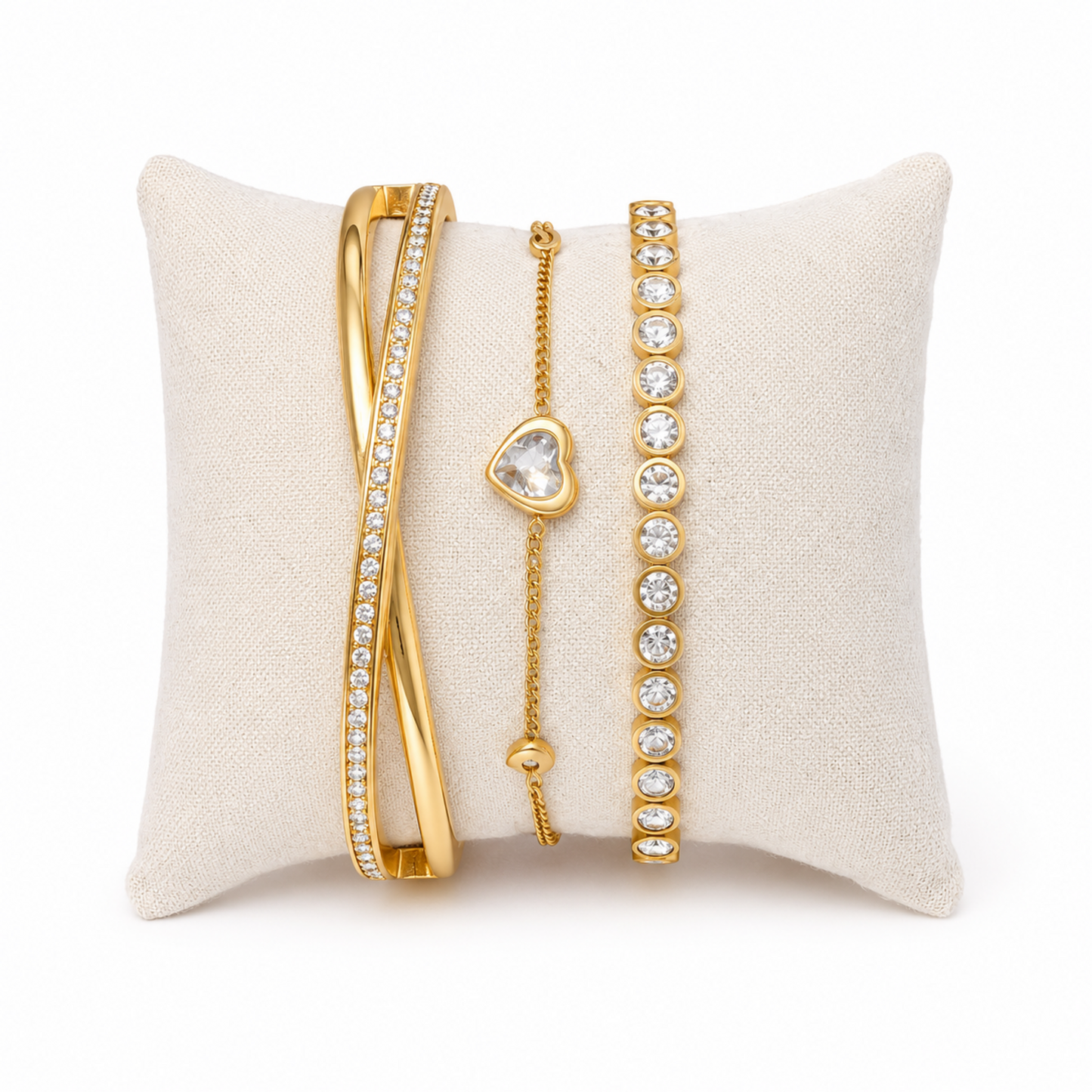 A premium three-piece gold-plated bracelet stack for women featuring a half-pavé crossover bangle, a sleek bezel-set crystal bangle, and a fine link chain with a single heart crystal charm