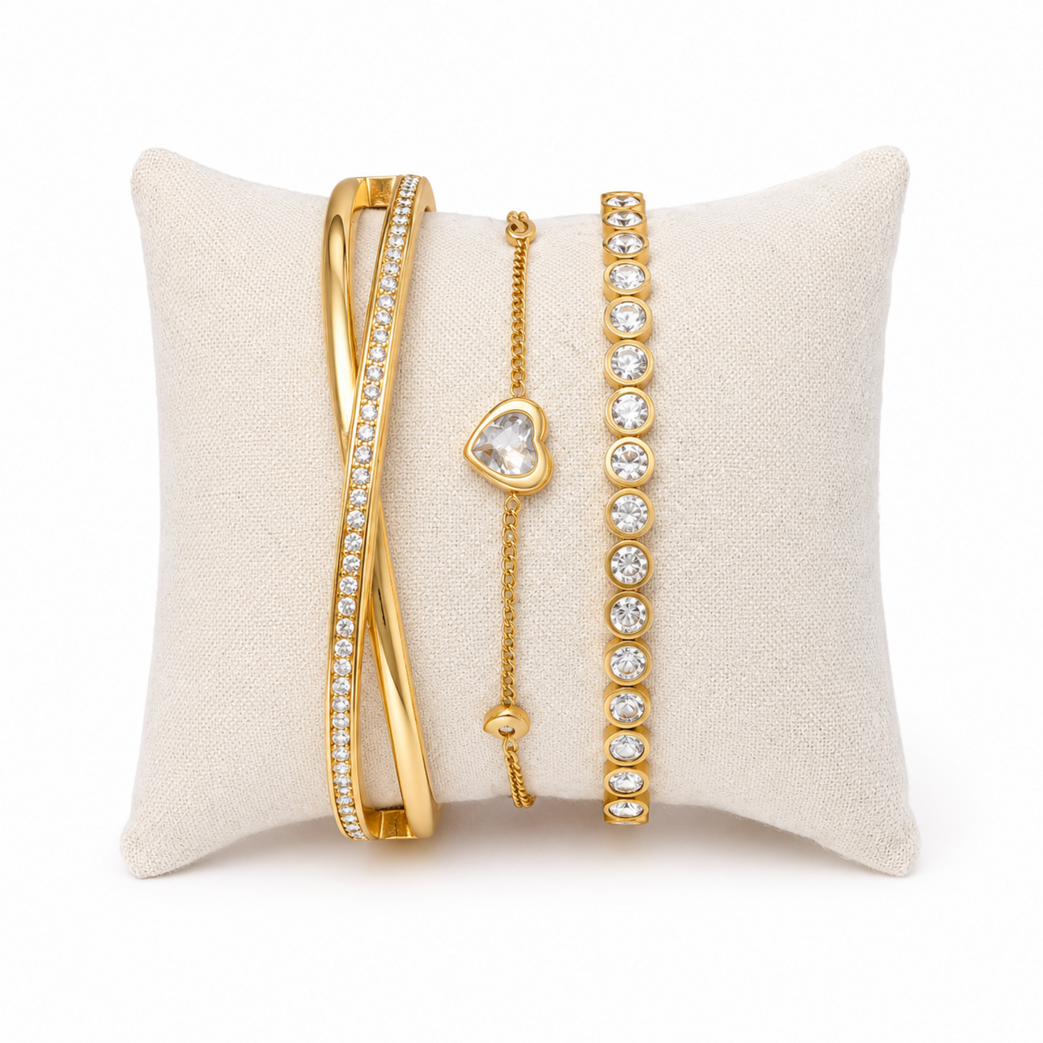 A premium three-piece gold-plated bracelet stack for women featuring a half-pavé crossover bangle, a sleek bezel-set crystal bangle, and a fine link chain with a single heart crystal charm