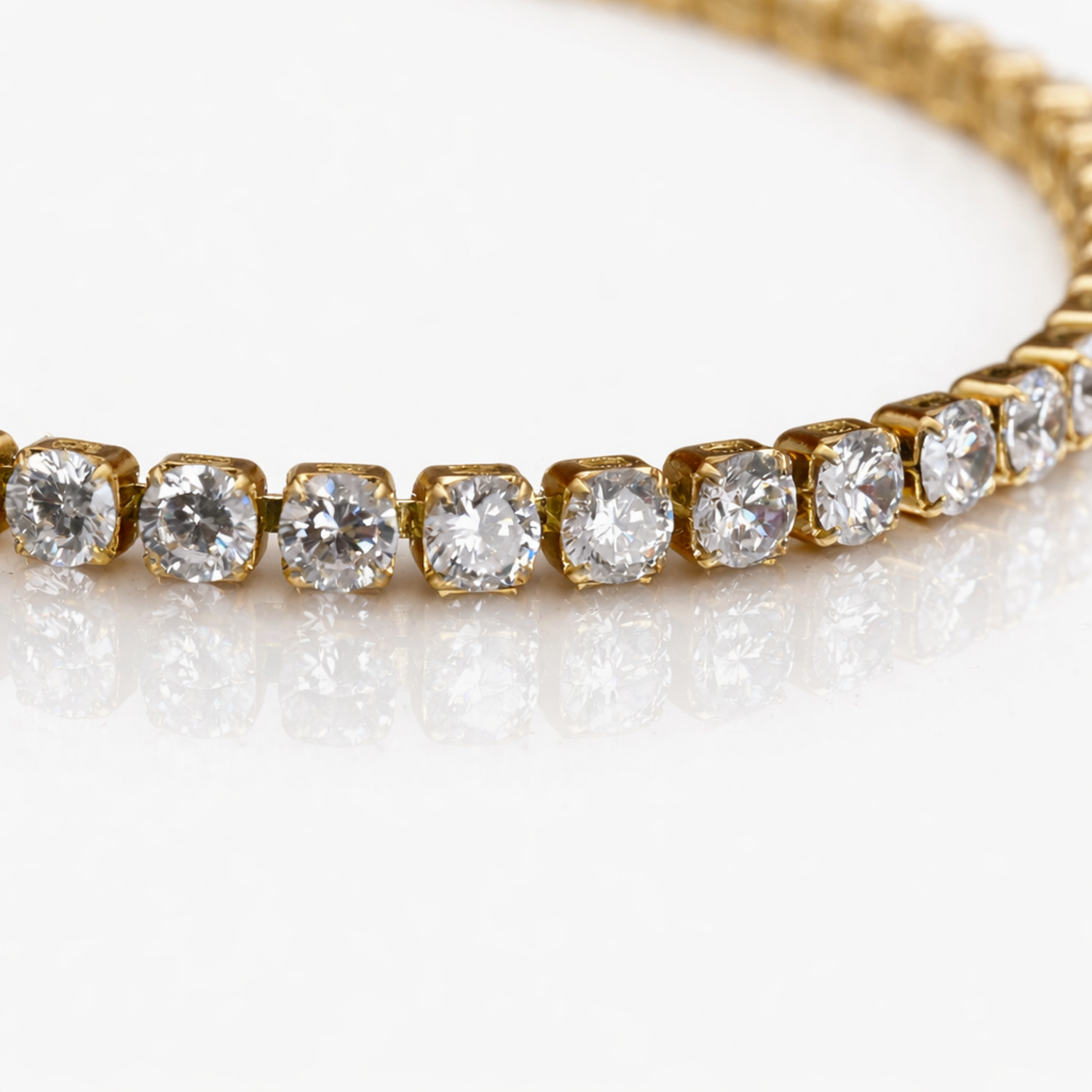 A close-view of a gold-plated tennis bracelet for women featuring a continuous row of brilliant round-cut stones, shown on a white background