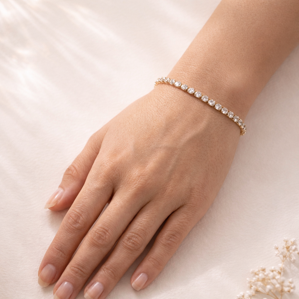 A classic gold-plated tennis bracelet for women featuring a continuous row of brilliant round-cut stones, shown on a model hand